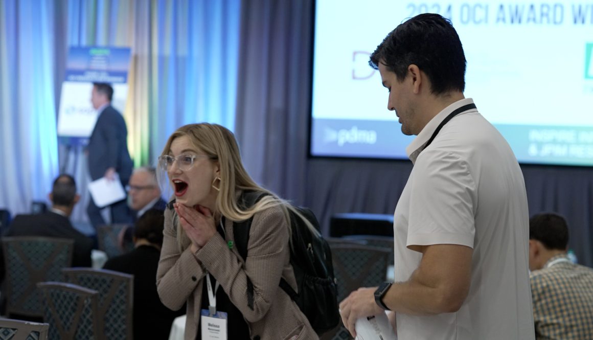 a color photo of a woman reacting to being announced as an award winner