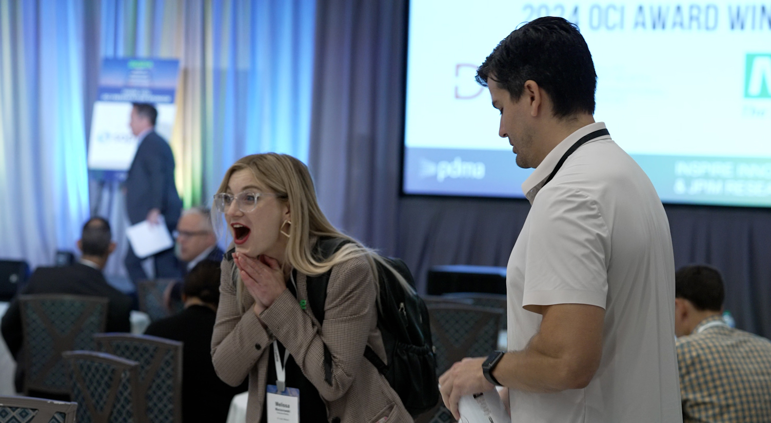 a color photo of a woman reacting to being announced as an award winner