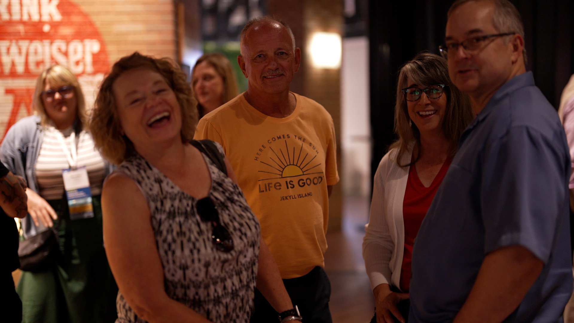 people at a conference event laughing and smiling at the camera